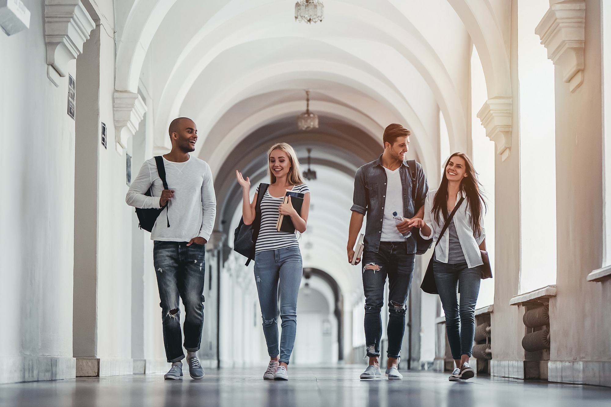 Multiracial students are walking in university hall